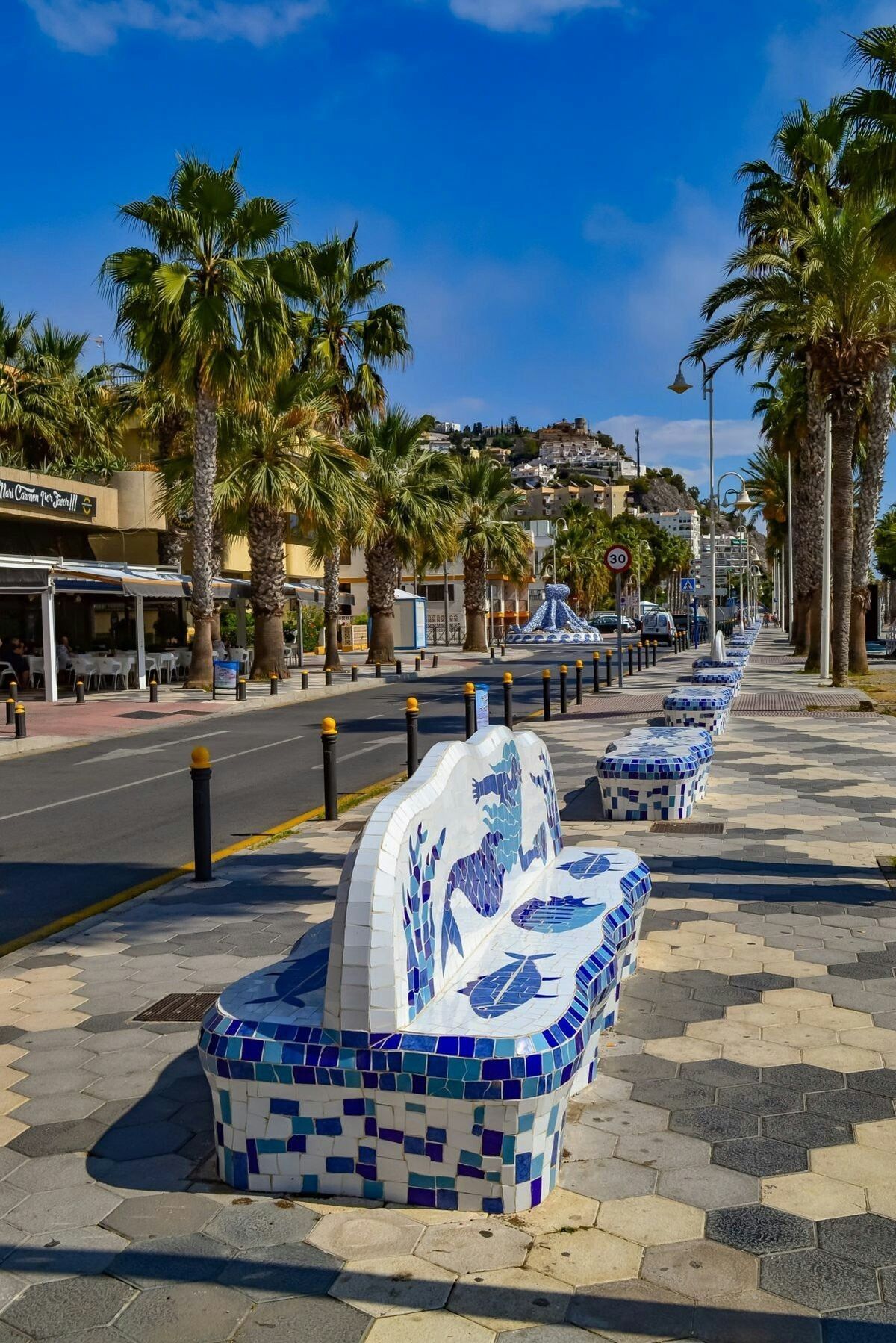 Almunecar palm promenade with ceramic benches and coastal light